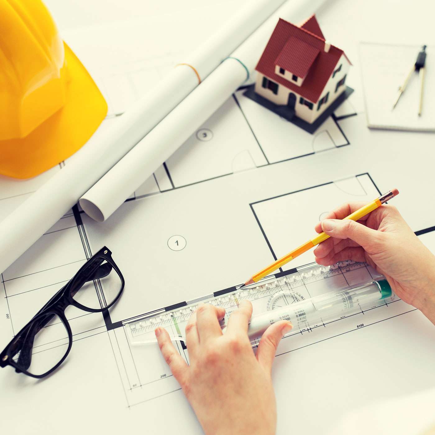 Our-Vision-close-up-of-hands-with-ruler-measuring-blueprint-PRTHEWT